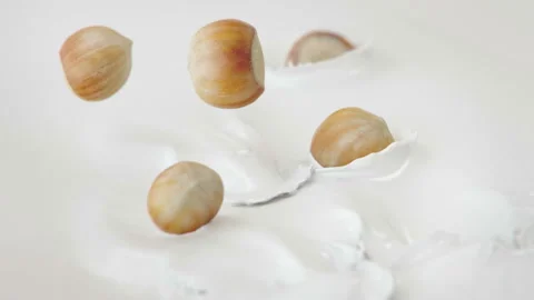 Hazelnuts Falling Into Milk in 4K Super slow motion Stock-Footage 139144845