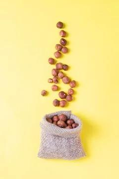 Hazelnuts, filbert in burlap sack on yellow paper. heap or stack of hazelnuts Stock Photos