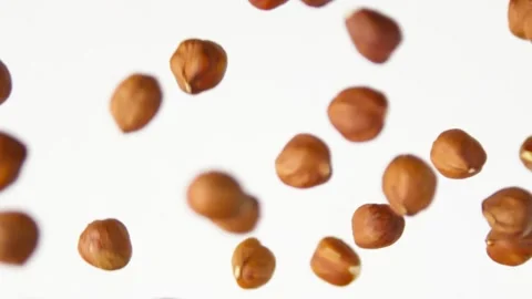 Hazelnuts flies on the white background slow motion Video stock 148553546