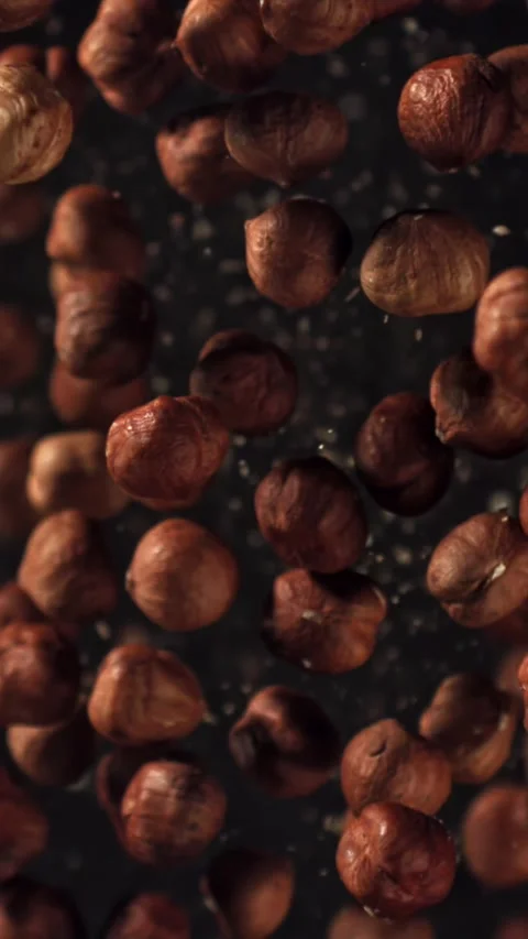 Hazelnuts fly up and fall down. Filmed on a high-speed camera at 1000 fps Stock Footage 335373795