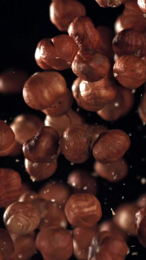 Hazelnuts fly up and fall down. Filmed on a high-speed camera at 1000 fps Stock Footage 335375660
