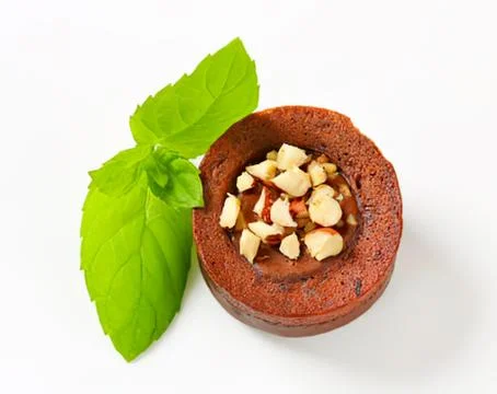Hazelnuts in a hollowed walnut with basil leaf Stock Photos