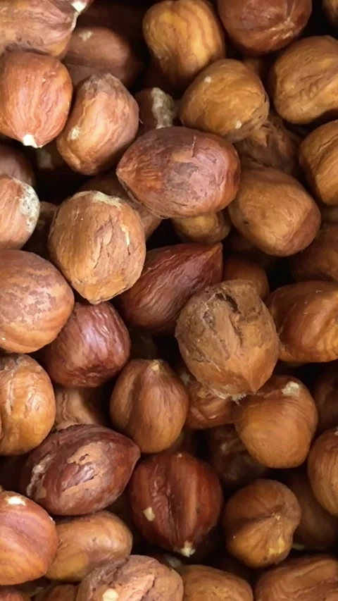 Hazelnuts with natural brown skin close up in transparent container with 库存影片 345722873