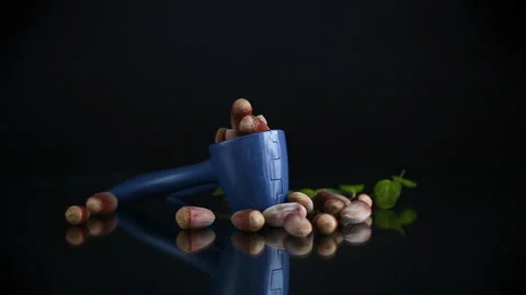Hazelnuts with nutcracker isolated on black background. Stock Footage 297690379