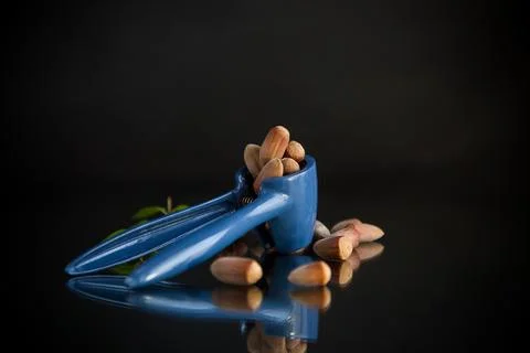 Hazelnuts with nutcracker isolated on black background Foto stock