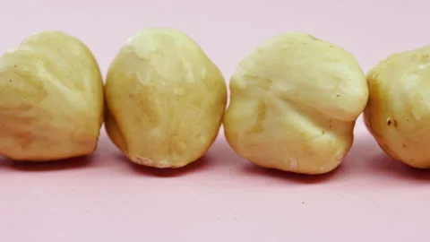 Hazelnuts on a pink background. Slow motion. Horizontal pan. Close-up. Stock Footage 155281925
