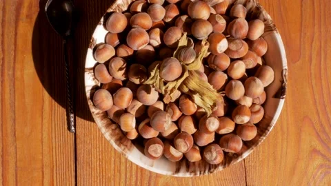 Hazelnuts in porcelain bowl with nutcracker on rustic wooden background 4K Stock Footage 139259816