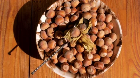 Hazelnuts in porcelain bowl with nutcracker on rustic wooden background 4K Stock Footage 139259951