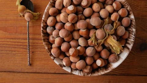 Hazelnuts in porcelain bowl with nutcracker on rustic wooden background 4K Stock Footage 139262720