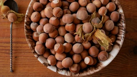 Hazelnuts in porcelain bowl with nutcracker on rustic wooden background 4K Stock Footage 139262822