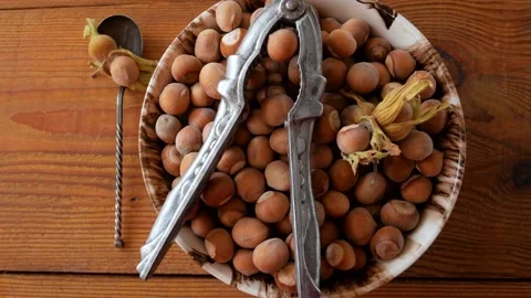 Hazelnuts in porcelain bowl with nutcracker on rustic wooden background 4K Stock Footage 139327649