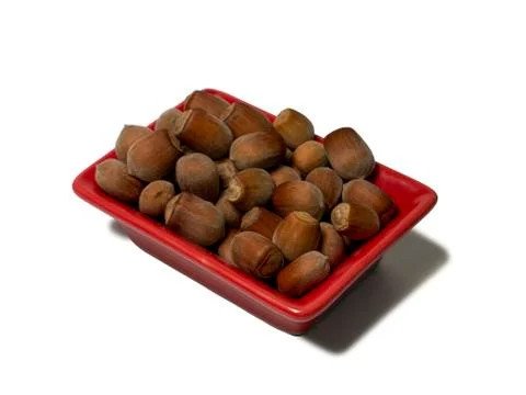 Hazelnuts in a red rectangular saucer isolated on white background. Close-up Stock Photos