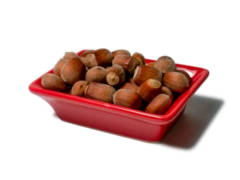 Hazelnuts in a red rectangular saucer isolated on white background. Close-up Stock Photos
