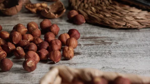 Hazelnuts rolling on a rustic table Stock Footage 152383727