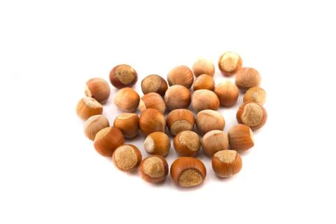Hazelnuts in the shape of a heart isolated on white Stock Photos