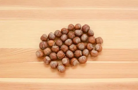 Hazelnuts in shells on wood Stock Photos