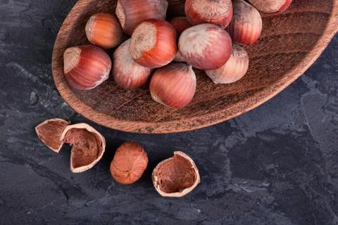 Hazelnuts in a spoon and one broken nut Stock Photos