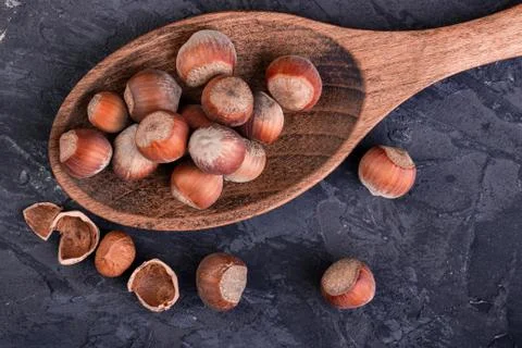 Hazelnuts in a spoon and one broken nut Stock Photos
