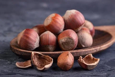 Hazelnuts in a spoon and one broken nut Stock Photos