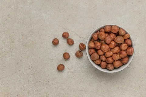 Hazelnuts on the table. A cup of hazelnuts flips over onto a marble top. Copy Stock Photos