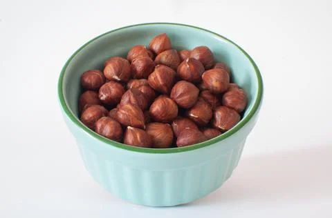 Hazelnuts without shells, turquoise color bowl filled with organic nuts. Stock Photos