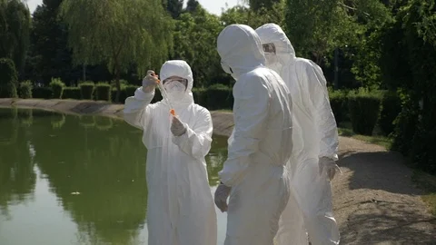 Hazmat technicians team taking infected water sample in a park and examining  Vídeos de archivo 82178573