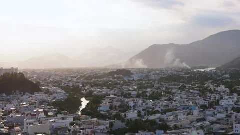 Hazy cityscape with mountains and river at sunset Stock Footage 344289048