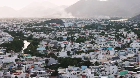 Hazy cityscape sprawling through a mountainous valley Stock Footage 344287035