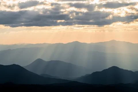 Hazy mountain range with dramatic sunset sky Stock Photos