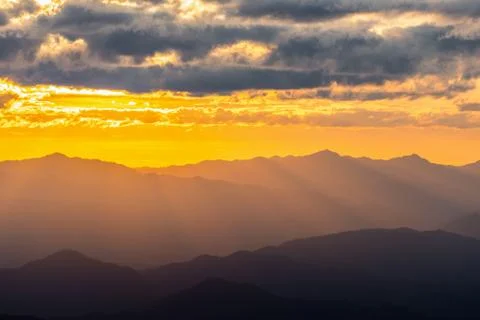 Hazy mountain range with dramatic sunset sky Stock Photos