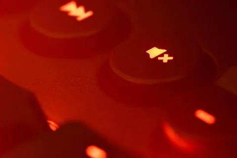 Hazy red illuminated keyboard mute key closeup Stock Photos