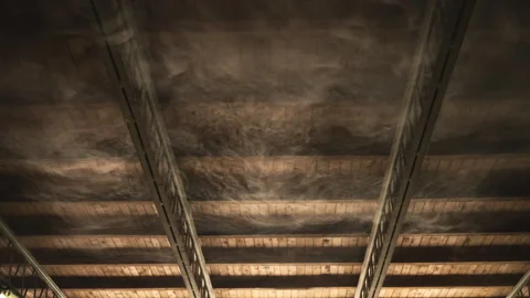 Hazy smoke clouds illuminated by overhead lighting in dark interior, abstra.. Stock Footage 343570322