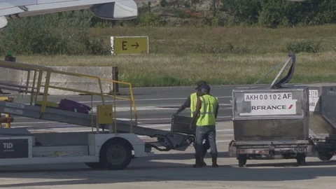 HD Airport ground support - workers move luggage from belt to luggage cart  Stock Footage 120135837