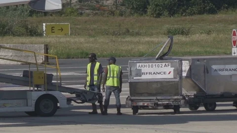 HD Airport ground support - workers move luggage from belt to luggage cart V2  Stock Footage 120135938