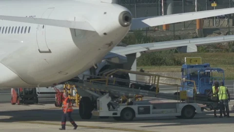 HD Airport ground support - workers move luggage from belt to luggage cart V3 Stock Footage 120135969