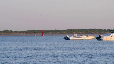 HD Cargo ship in background passing behind fishing boats on beach Stock Footage 75423933