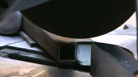HD Circular saw blade teeth coming through a steel section, closeup Stock Footage 611789
