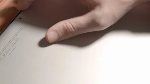 HD Closeup view how computer technician opens the bottom cover of Macbook Stock-Footage 94450086