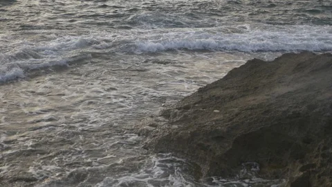 HD down view of rocky coastline tilting up to ocean during the afternoon. Stock Footage 116058860