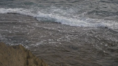 HD down view of rocky coastline tilting up to ocean during the afternoon. Stock Footage 116059229