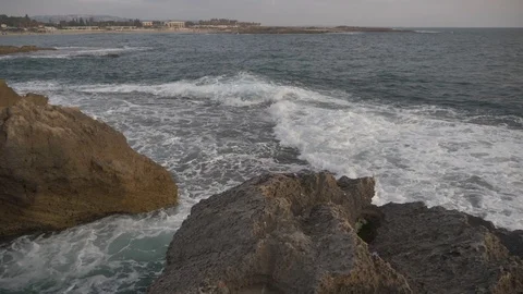 HD down view of rocky coastline tilting up to ocean during the afternoon. Stock Footage 116059404