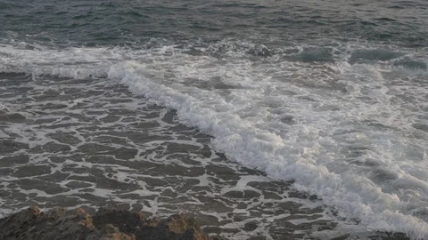HD down view of rocky coastline tilting up to ocean during the afternoon. Stock Footage 116059659