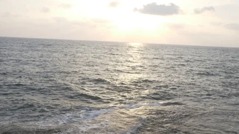 HD down view of rocky coastline tilting up to ocean during the afternoon. Stock Footage 116059890