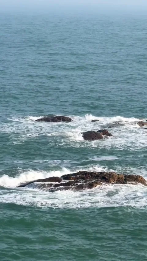 HD drone footage of powerful ocean waves crashing on rocky shore with sea spray Vidéo 333605290