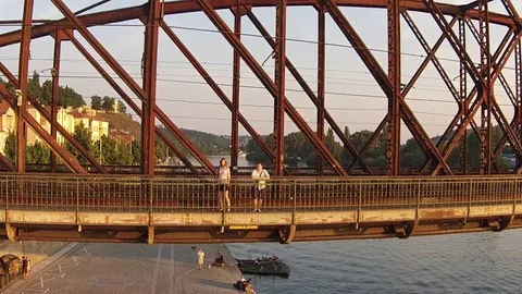HD EXT DAY aerial camera pull back railway bridge above the river with a couple Stock Footage 73425165