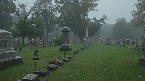 HD EXT DAY handheld cemetery with US flags in the rain Stock Footage 73803012