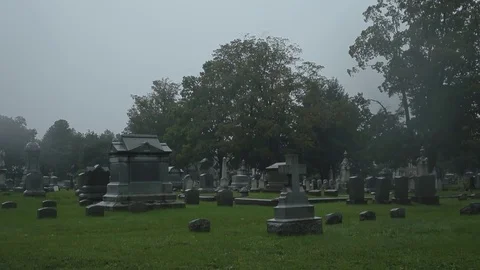 HD EXT DAY handheld cemetery in the rain Stock Footage 73803018
