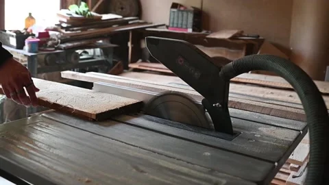 HD footage displaying a man using a circular electric saw to cut a wood plank in Stock Footage 131055724