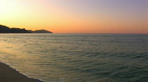 HD Gentle waves on a sandy beach in sunrise, rocks background Stock Footage 597958