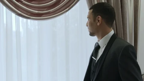 HD Groom is standing next to window before ceremony Stock-Footage 97168582